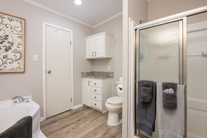 A bathroom with a bathtub, toilet, and shower.