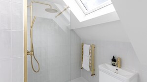 Une salle de bain moderne avec un puits de lumière, une douche et des toilettes.