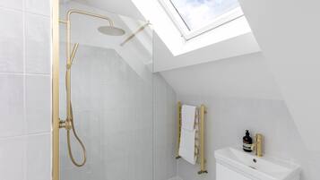 Ein modernes Badezimmer mit Dachfenster, Dusche und Toilette.
