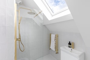 A modern bathroom with a skylight, a shower, and a toilet. - Stylish Apartment in Converted 18th-Century Guest House | Central Rothbury (Rothbury)
