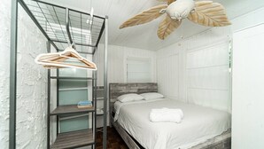 A bedroom with a bed, a wooden headboard, a hanging clothes rack, and a ceiling fan. - Bike to Beach-Spacious With Patio BBQ Plus Game Room (Hallandale Beach)