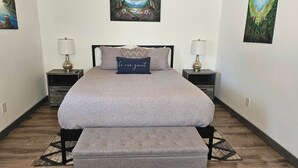 A neatly arranged bedroom with a large bed, two bedside tables, and a bench. - Modern container cabin on 13 acre country estate (Sequim)