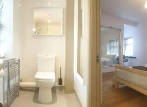 A bathroom with a toilet, a mirror, and a radiator.