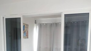 Un dormitorio con una cama, una puerta corrediza de cristal y un cuadro en la pared.