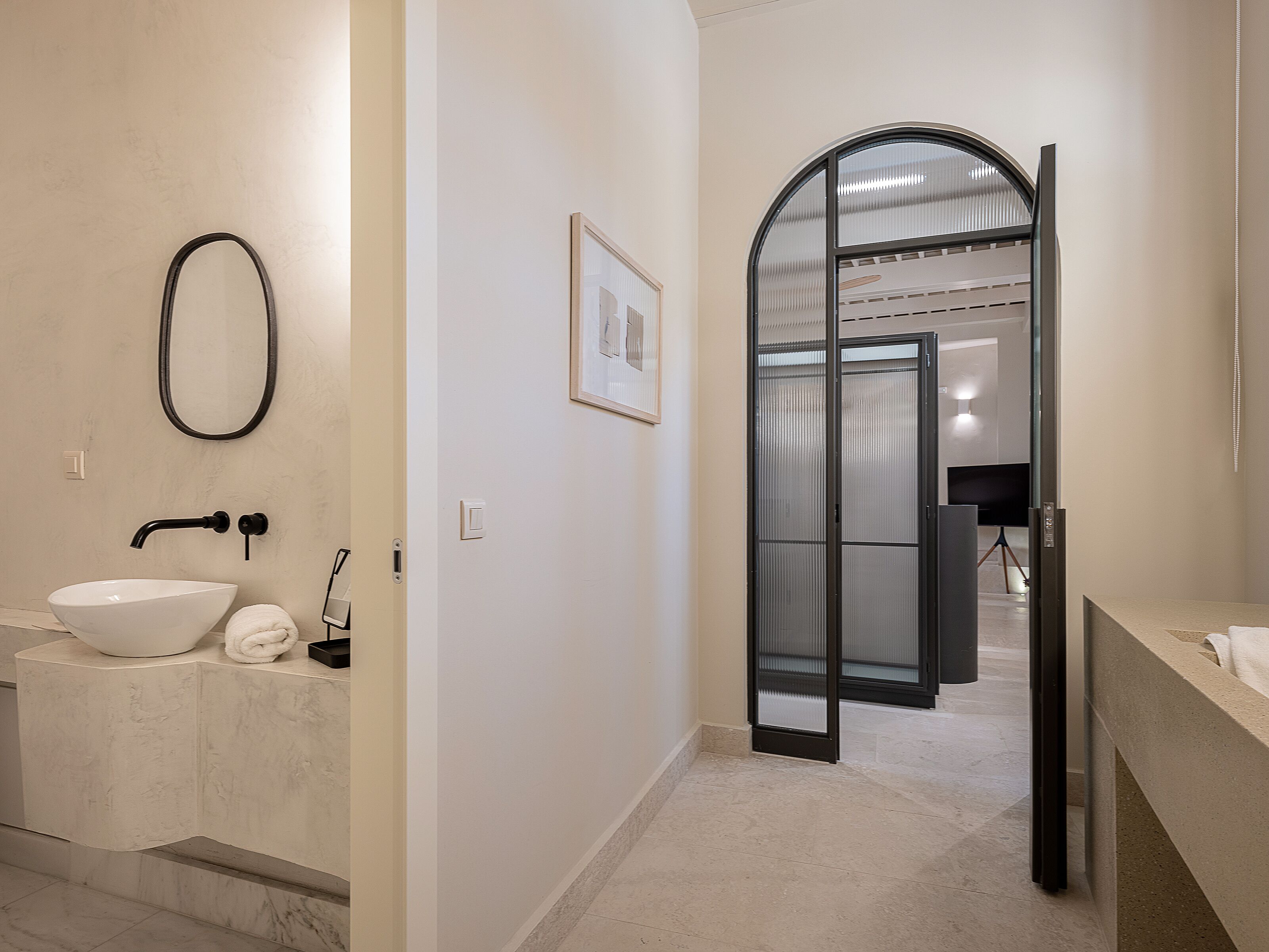 Un baño moderno con un lavamanos blanco, una toalla y una ducha.