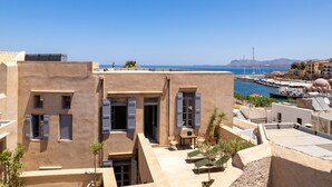 A rooftop terrace with a view of the sea, featuring a table and chairs, and a small garden area. - Azade Chania (Chania)