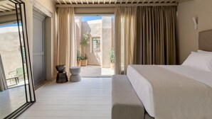 A hotel room with a bed, a ceiling fan, a balcony with curtains, and potted plants. - Azade Chania (Chania)