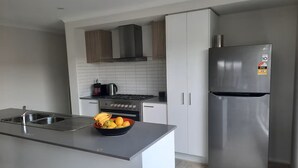 Een moderne keuken met roestvrijstalen apparatuur, een inbouwoven en een koelkast.