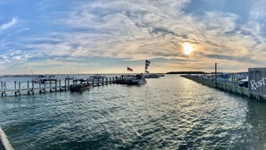 A waterfront view with a pier extending into the water, boats docked, and a wooden wall with the text "Rusty Rudder". - 4 Nights Left -Perfect Family-Friendly Condo 5 Houses from the Ocean-Beach Block (Dewey Beach)