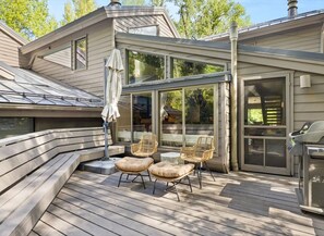 A deck with outdoor seating and a grill.