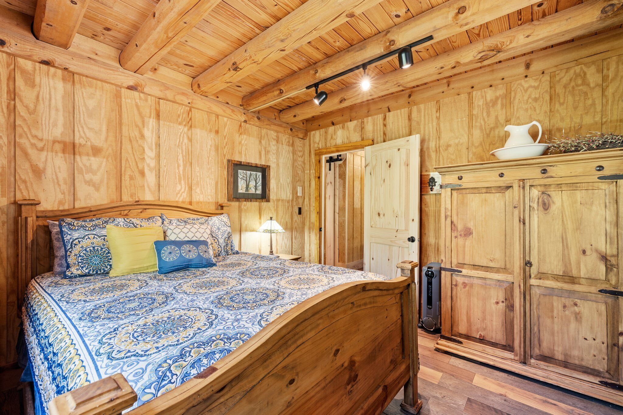Une pièce en bois avec un lit, une table de chevet et une armoire.