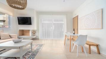 Een moderne woonkamer met een bank, salontafel en eethoek.