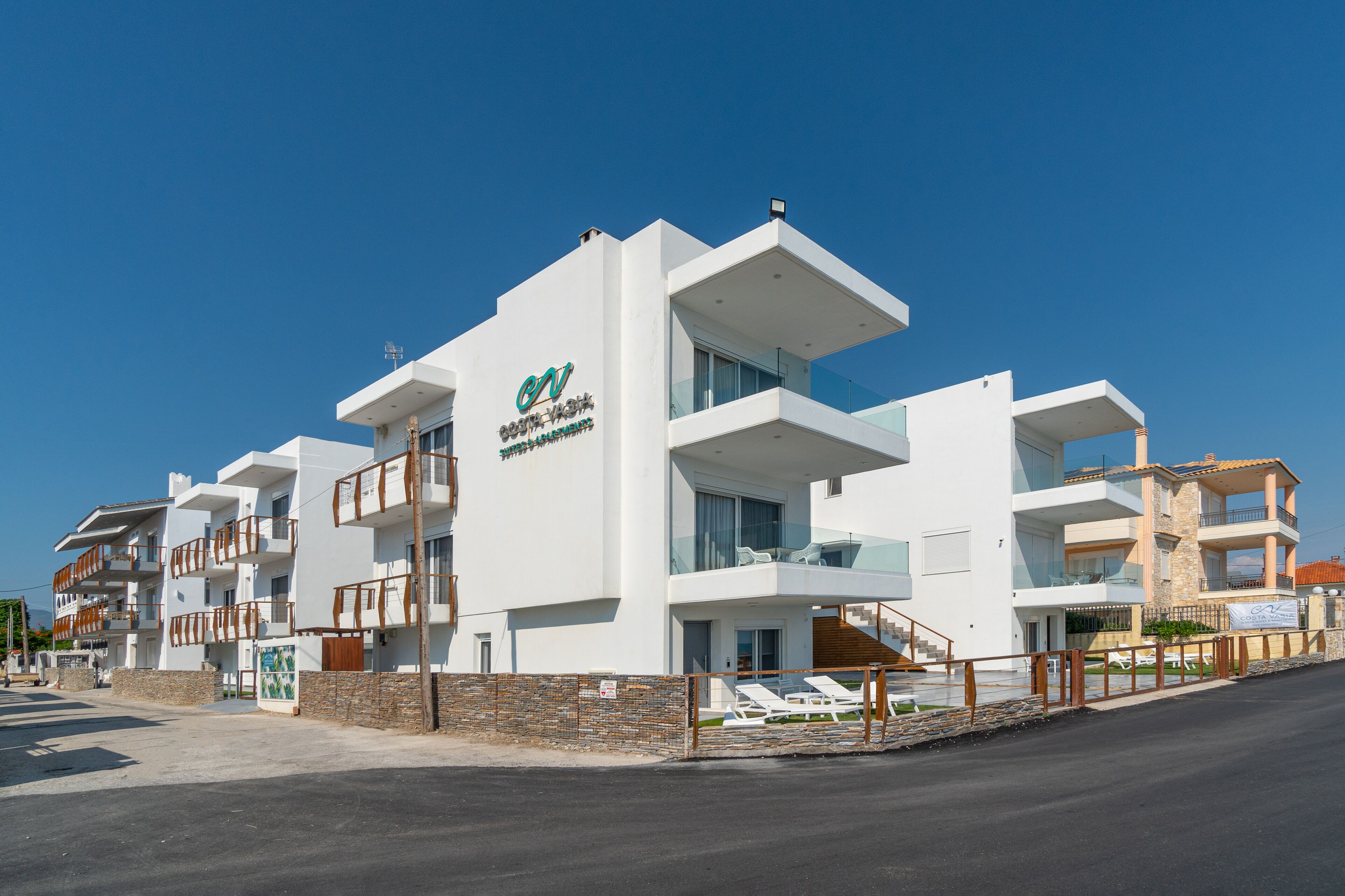 Un hôtel moderne doté de nombreux balcons, d’un logo bien visible et offrant une vue dégagée sur les environs.