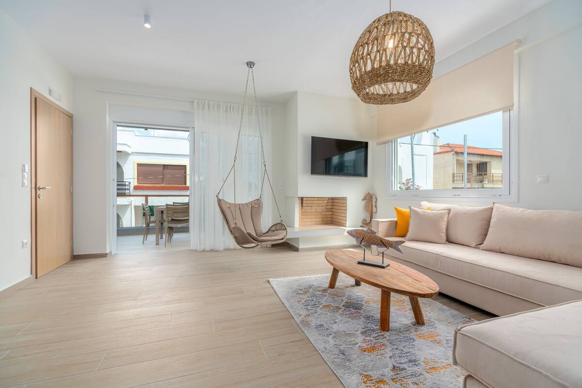A modern living room with a sofa, a hanging chair, and a coffee table.