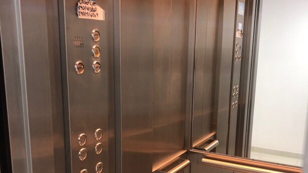 An elevator interior with a control panel, emergency instructions, and a handrail. - IN FRONT OF THE BEAGLE. YOUR PLACE IN USHUAIA (Ushuaia)