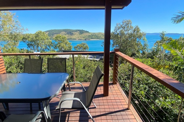 Private ocean-view balcony with outdoor dining and sunset views