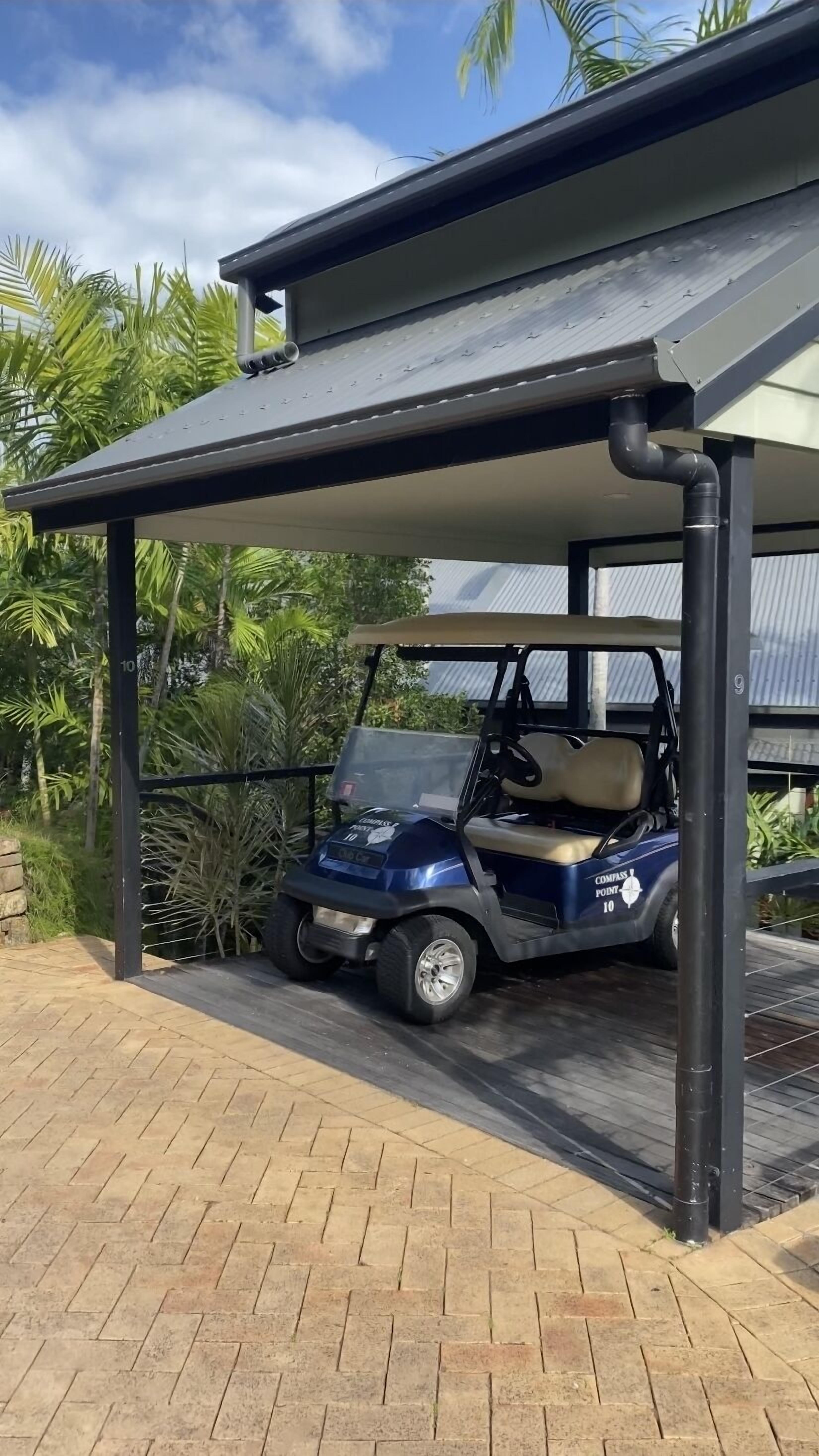 A covered parking area with a golf cart parked under a shelter.