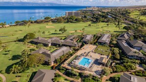 Eine Luftaufnahme eines Resorts mit Schwimmbad, Golfplatz und Meerblick.