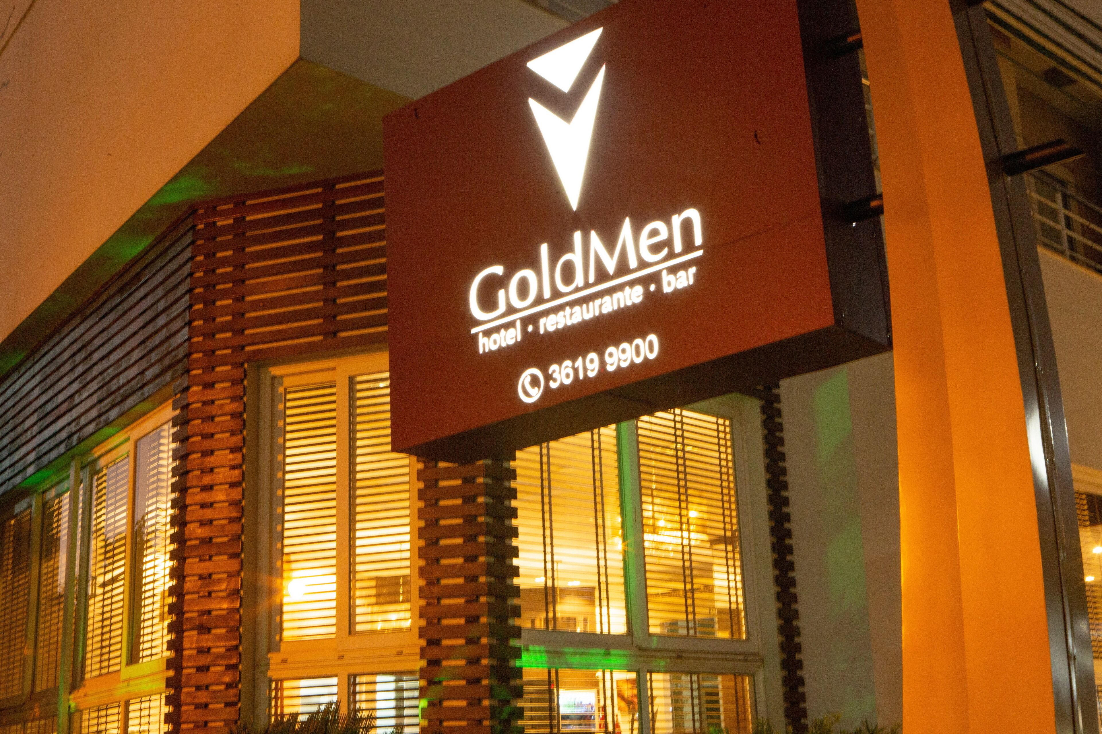 A hotel sign with the name 'GoldMen' and contact number '3619 9900'.