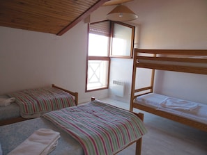 A room with two bunk beds, a window with blinds, a radiator, and a ceiling fan. - On the seafront, 1-star apartment for 6 people in Mimizan Plage Nord (MIMIZAN PLAGE)