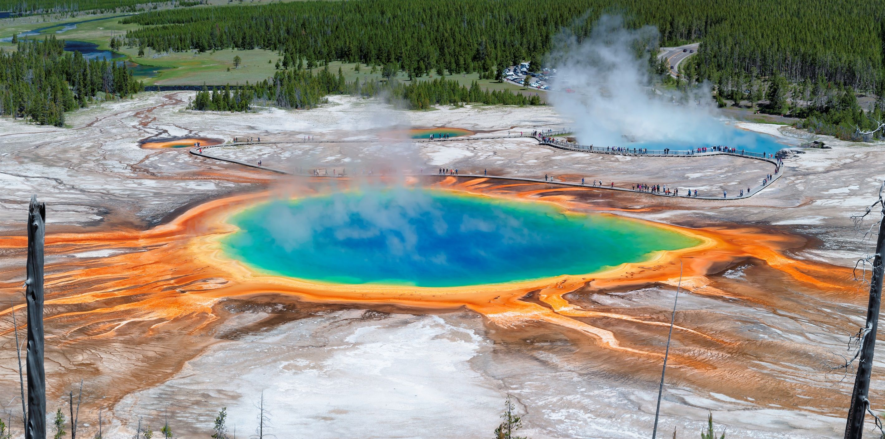 Una fuente termal geotérmica con una piscina circular rodeada de depósitos minerales.