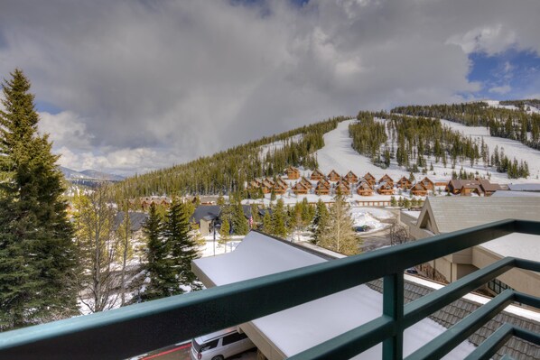 A snow-covered mountain resort with wooden cabins and a ski slope.
