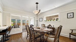 Un coin repas avec une table en bois, dressée pour quatre personnes, entourée de chaises.
