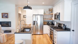 Una cocina moderna con armarios blancos, electrodomésticos de acero inoxidable y una isla central.