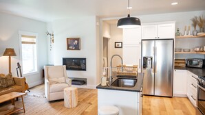 Una cocina moderna con armarios blancos, un refrigerador de acero inoxidable y una isla integrada con pileta.