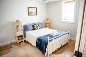 A neatly arranged bedroom with a bed, bedside tables, a lamp, and a window. - The Washburn House - Kid friendly! (Missoula)