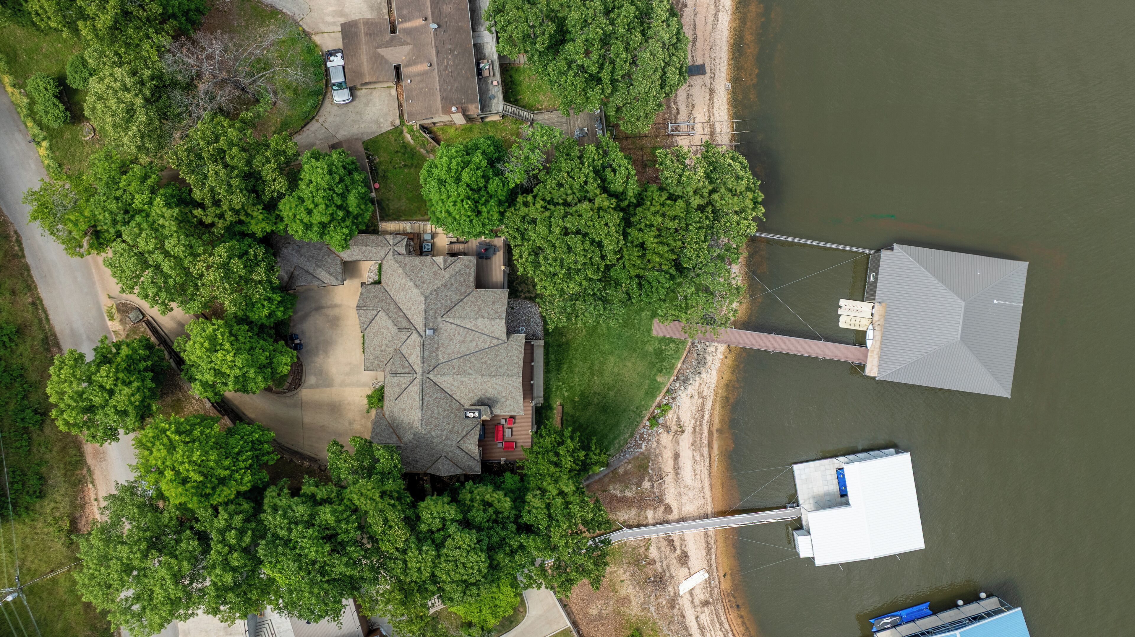 Vue aérienne d’une propriété comprenant une maison, un quai et un bateau.