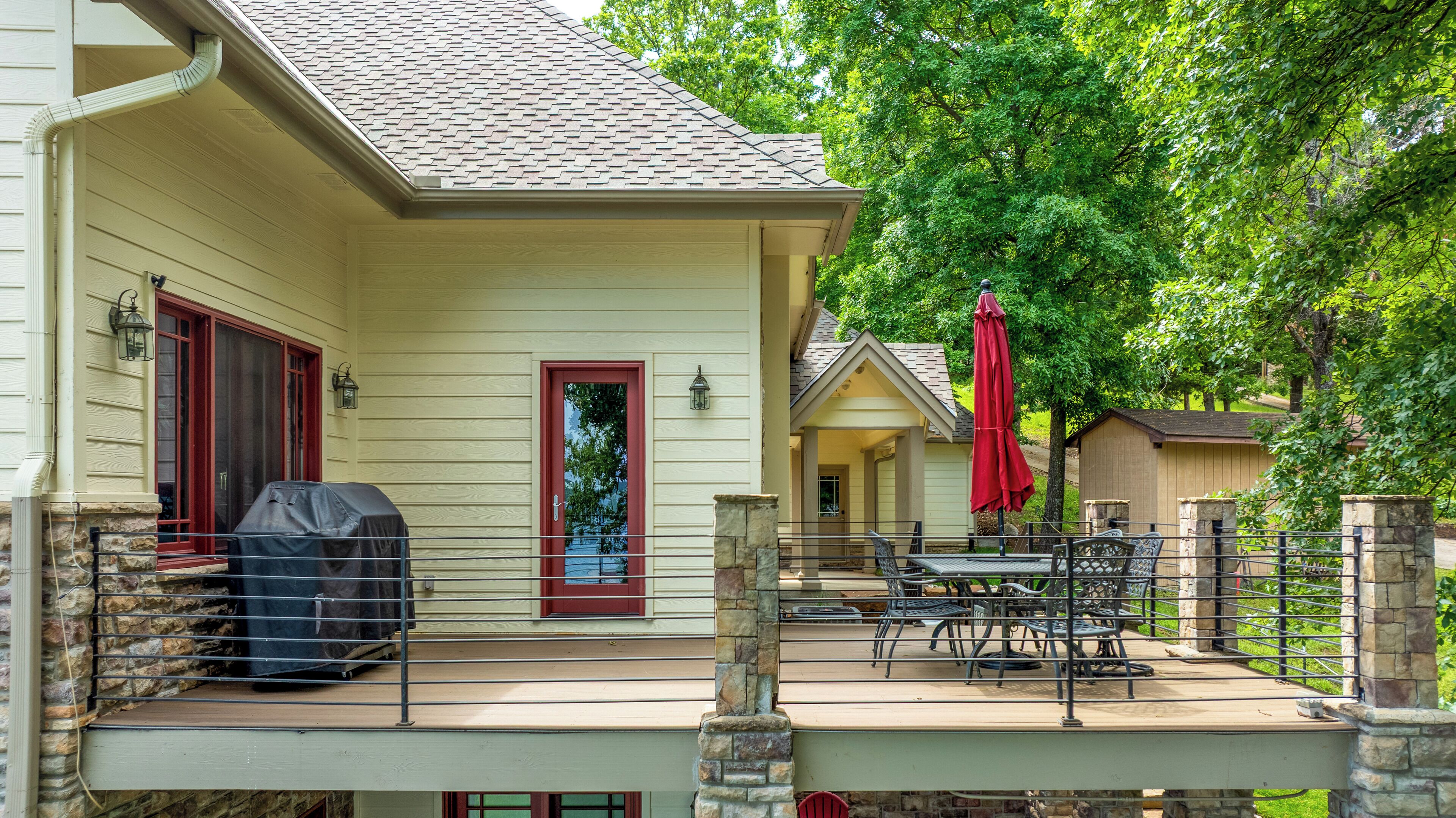 A covered patio with outdoor furniture and a barbecue grill.