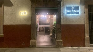 An entrance to a building with a sign reading "DON CARLOS" and a number "120" above the door. - Hotel Don Carlos (Morelia)