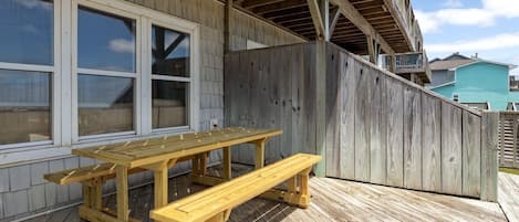 A wooden deck with a picnic table and a wooden fence.
