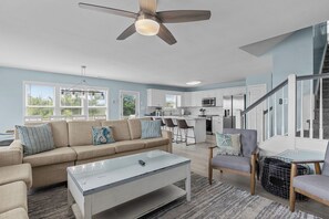 Un salon moderne avec un canapé, une table basse et un ventilateur de plafond.