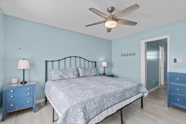 A bedroom with a bed, two bedside tables, a ceiling fan, and a dresser. - Shore Thing West -Spacious Beachfront Oasis & Pool - 5BR (Emerald Isle)