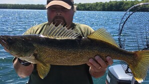 A person holding a large fish on a boat with a Yamaha outboard motor and a red cover labeled "PRINCICRA". - Kagawong Blue (Spring Bay)