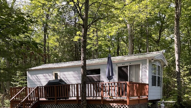 A mobile home with a deck, outdoor grill, and a covered patio area. - Kagawong Blue (Spring Bay)