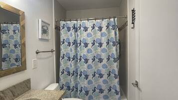 Tina con regadera, secadora de cabello, toallas, jabón