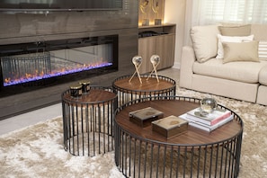 Cozy up by the fireplace in this inviting living room, featuring a comfortable sofa and flat-screen TV.