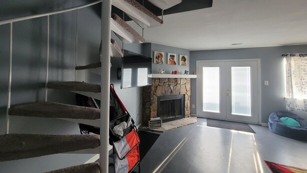 A multi-level living space with a staircase, a fireplace, and a sofa. - The Heart of Raleigh (Raleigh)