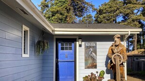Un edificio con puerta azul, una estatua de madera y un letrero que dice "RIVER VIEW".