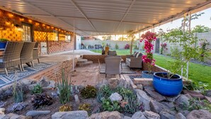 An outdoor patio with a covered seating area, stone pathways, and potted plants. - Gem in Heart of Old Town Scottsdale  (Scottsdale)