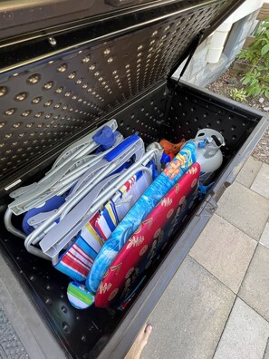 A black utility drawer in a vehicle filled with various items including a gas cylinder, a blue and red patterned bag, and several metal tools. - Modern Farmhouse, Sleeps 8, North of St. Joseph (Benton Harbor)