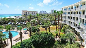Ein Resort mit Pool, Palmen und Blick aufs Meer.