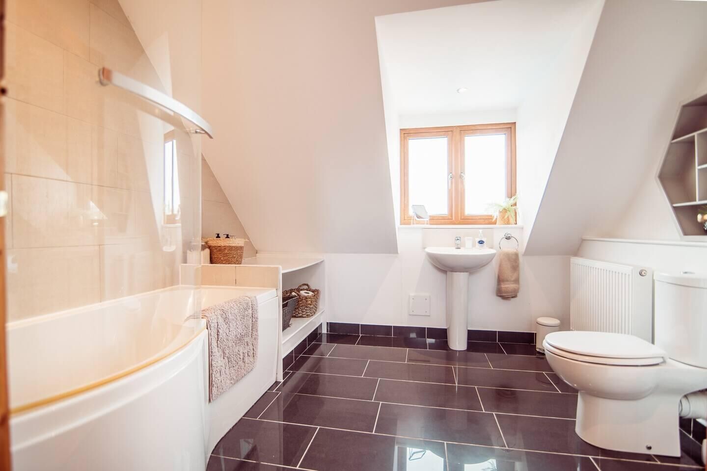 Un baño moderno con bañera, lavamanos e inodoro.