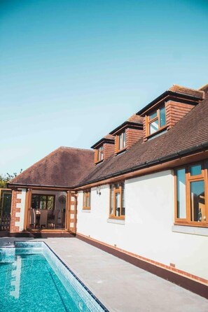 A two-story house with a swimming pool, a covered patio, and a brick exterior. - Threeways Retreat with Heated Swimming Pool (Dover)