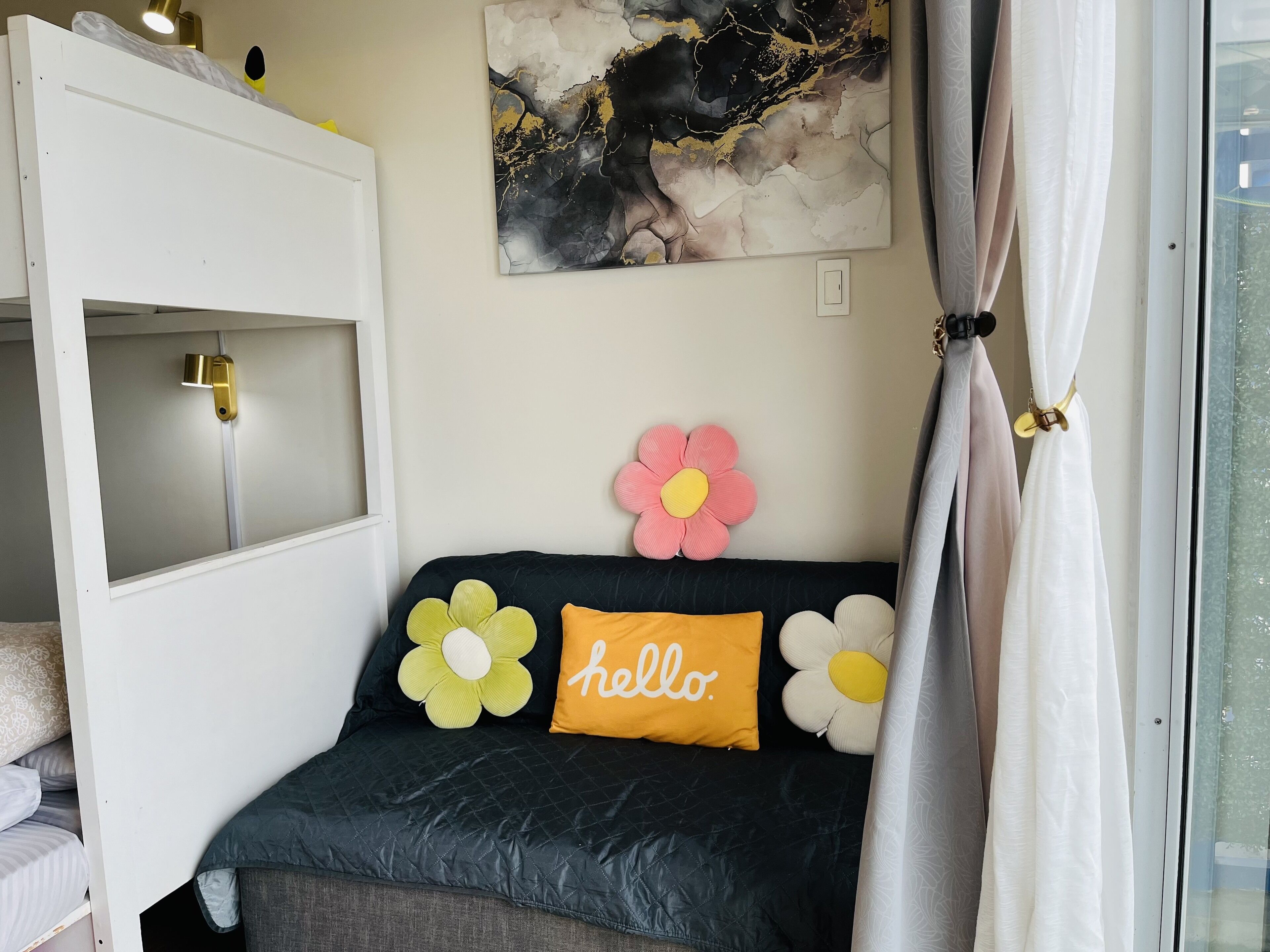 Un dormitorio acogedor con cama, ventana con cortinas, luz fijada en la pared y un tapiz floral decorativo.
