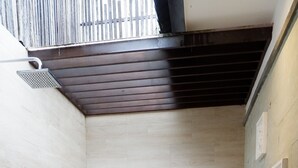 A bathroom with a freestanding bathtub, tiled walls, and a wooden floor.