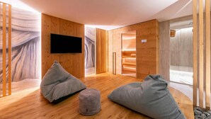A modern room with wooden walls, a flat-screen TV, and two bean bags. - Menina, Livigno, Italy (Livigno)